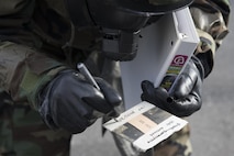 Senior Airman Collin Eddington, 374th Maintenance Squadron ISO aerospace maintenance apprentice, writes the date and time on a simulated M8 Chemical Agent Detection Paper during the Wartime Readiness Inspection at Yokota Air Base, Japan, Feb. 8, 2017. The inspection was designed to evaluate Yokota’s ability to provide airlift capabilities while responding to a variety of real-world scenarios. (U.S. Air Force photo by Yasuo Osakabe/Released)