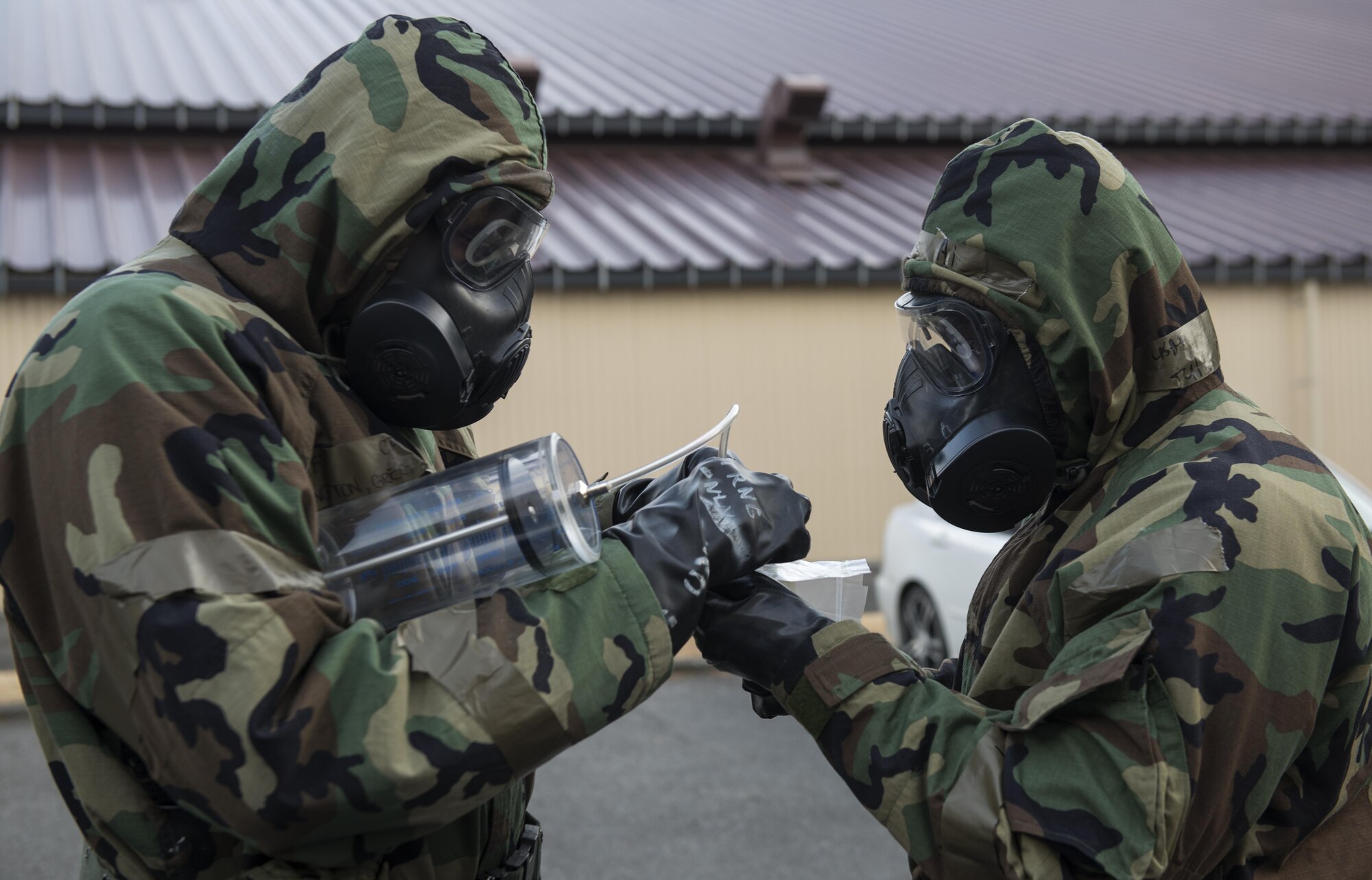 Capt. Gregory Arrington, 374th Aerospace Medicine Squadron bioenvironmental engineering flight chief, left, and Airman 1st Class Julius Dinkins, 374 AMDS bioenvironmental engineering journeyman, prepare to take an air sample for testing during a Wartime Readiness Inspection Feb. 8, 2017, at Yokota Air Base, Japan. During the inspection, Yokota's airlift capabilities were tested in a variety of real-world scenarios. (U.S. Air Force photo by Airman 1st Class Juan Torres)