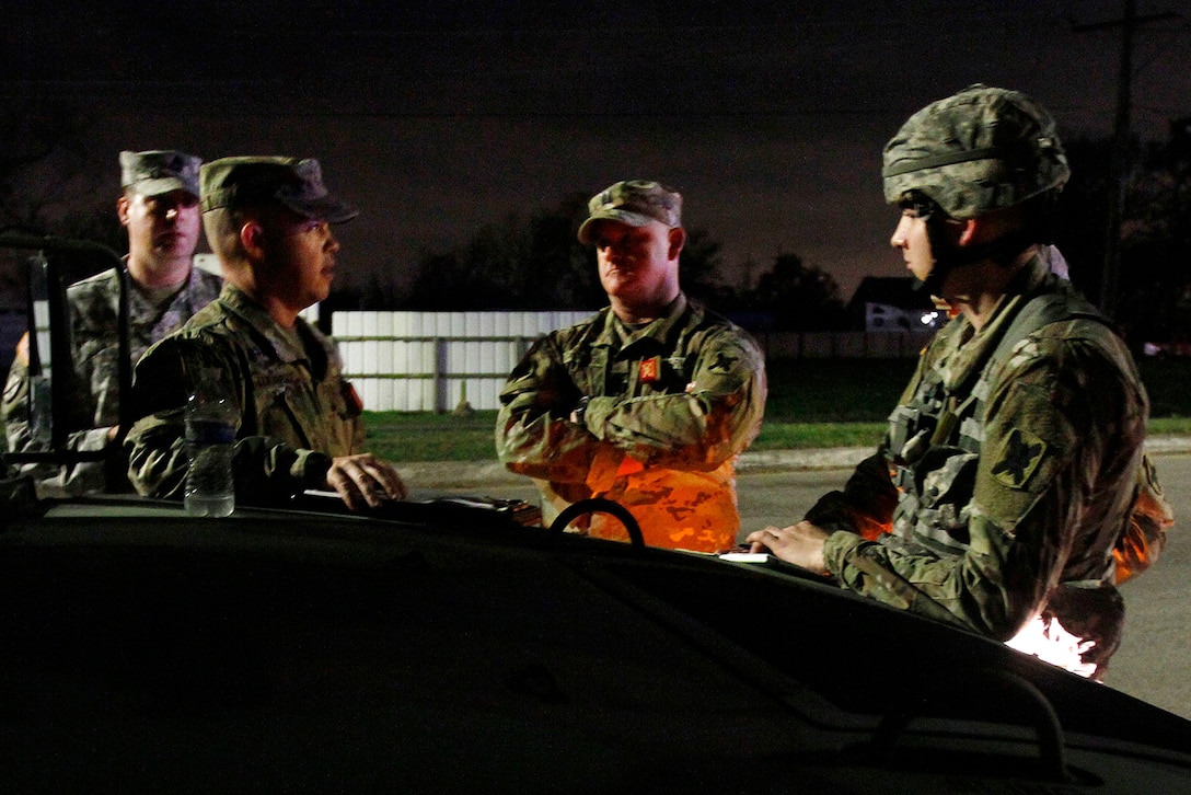 Louisiana Army National Guardsmen discuss security procedures before supporting night operations at 16 static traffic control points assisting local law enforcement agencies, emergency first responders and state officials after severe thunderstorms spawned several tornados near New Orleans, Feb. 8, 2016. Louisiana Army National Guard photo by Spc. Garrett Dipuma