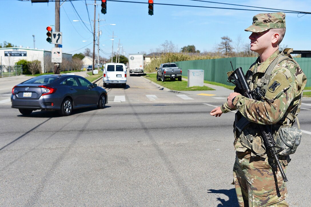 Army Louisiana National Guardsman Sgt. Brian Smith directs traffic at a static traffic control point after severe thunderstorms spawned several tornados near New Orleans, Feb. 9, 2016. Smith is assigned to the Louisiana Army National Guard’s 2nd Battalion, 156th Infantry Regiment. Louisiana Air National Guard photo by MSgt. Toby Valadie