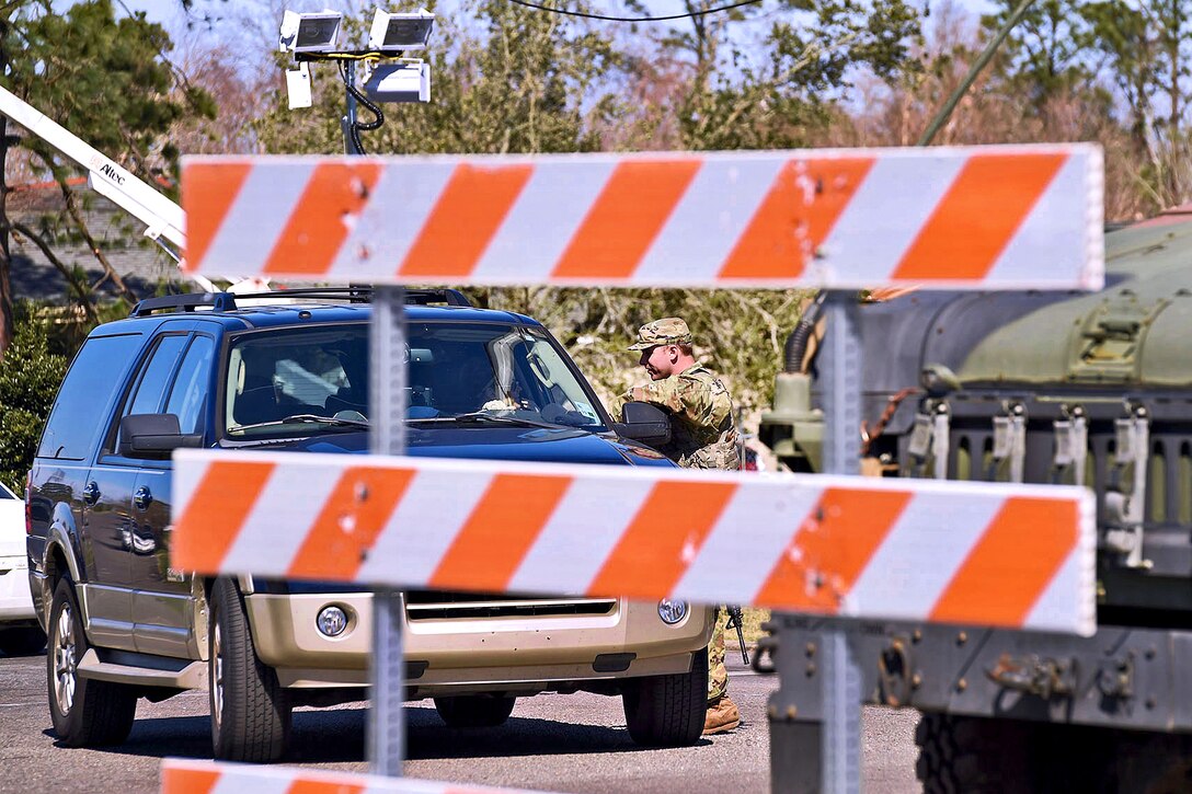 Louisiana Army National Guard Spc. Billy Pitre speaks with a driver at a static traffic control point after severe thunderstorms spawned several tornados near New Orleans, Feb. 9, 2016. Pitre is assigned to the Louisiana Army National Guard’s 2nd Battalion, 156th Infantry Regiment. Louisiana Air National Guard photo by Master Sgt. Toby M. Valadie