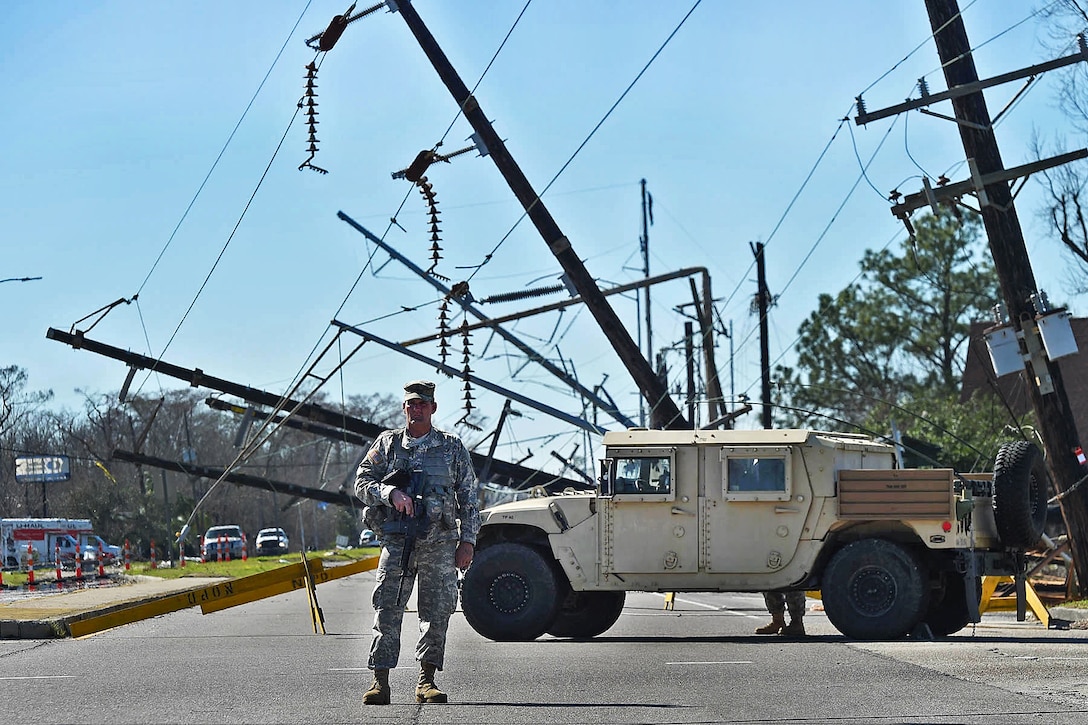 Louisiana Army National Guardsman Staff Sgt. Casey Delcambre directs traffic away from fallen power lines after severe thunderstorms spawned several tornados near New Orleans, Feb. 9, 2016. Delcambre is assigned to the Louisiana Army National Guard’s 2nd Battalion, 156th Infantry Regiment. Louisiana Air National Guard photo by Master Sgt. Toby M. Valadie