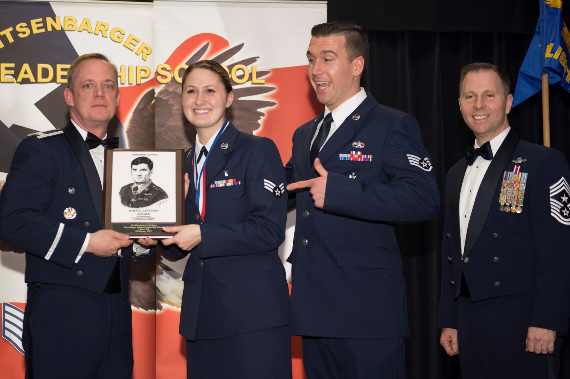 U.S. Air Force Senior Airman Kimberly DeVeau, center, Medical Operations Squadron medical technician, receives the John L. Levitow during the Pitsenbarger Airman Leadership School 17-B graduation at Club Eifel on Spangdahlem Air Base, Germany, Feb. 9, 2017. The Levitow award is the highest honor given to the student who displays excellence in all categories of ALS.
