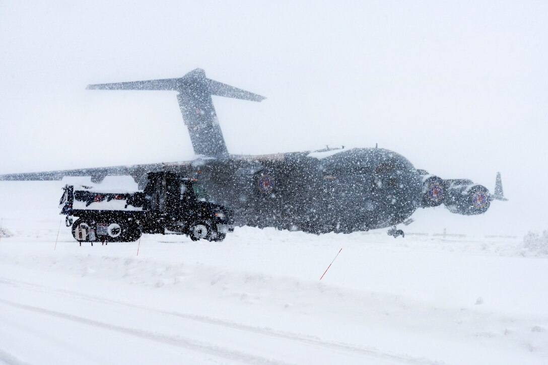 New York Air National Guardsmen drive a dump truck past a C-17 Globemaster III cargo plane while conducting snow removal operations on the flight line at Stewart Air National Guard Base, Newburgh, N.Y., Feb. 9, 2017. The guardsmen are assigned to the New York Air National Guard’s 105th Civil Engineer Squadron, 105th Airlift Wing. Air National Guard photo by Staff Sgt. Julio A. Olivencia Jr.
