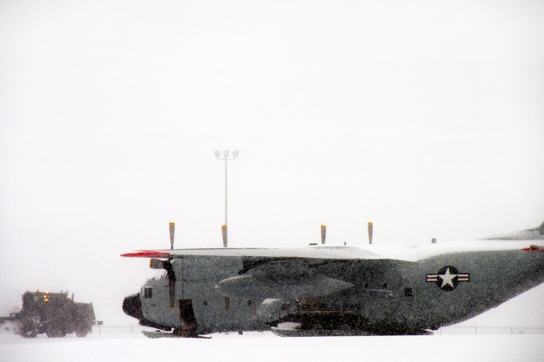 A New York Air National Guardsman drives a snowblower past a LC-130 Hercules Skibird aircraft while removing snow from the flight line at Stratton Air National Guard Base, Schenectady, N.Y., Feb. 9, 2017. The guardsman is assigned to the New York Air National Guard’s 109th Airlift Wing. Air National Guard photo by Master Sgt. William Gizara