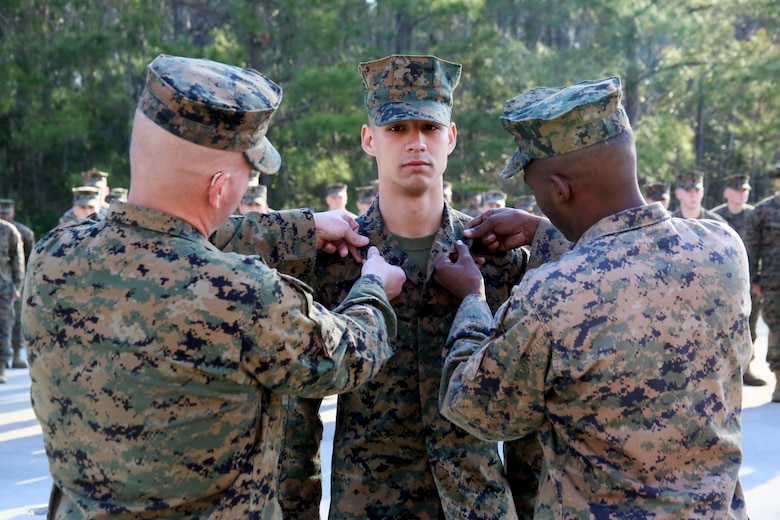 Sgt. Ryan Tugas, center, is pinned as a meritorious sergeant during a promotion ceremony aboard Marine Corps Air Station Cherry Point, N.C., Feb 2, 2017. Marine Tactical Air Command Squadron 28’s senior leadership recognized Tugas for going above and beyond the call of duty while assigned as the assistant motor transport operations chief. Tugas is a motor transport operator assigned to MTACS-28, Marine Air Control Group 28, 2nd Marine Aircraft Wing. (U.S. Marine Corps photo by Cpl. Mackenzie Gibson/ Released)
