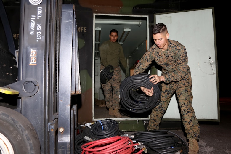 Sgt. Ryan Tugas, right, assists Cpl. Ayman Khan in stacking rolled cords onto a fork lift during an inspection aboard Marine Corps Air Station Cherry Point, N.C., Jan. 31, 2017. In addition to being a motor transport operator, during his free time, Tugas volunteered 30 hours to Roger Bell Elementary School by tutoring and reading to students. Tugas is assigned to Marine Tactical Air Command Squadron 28, Marine Air Control Group 28, 2nd Marine Aircraft Wing. (U.S. Marine Corps photo by Cpl. Jason Jimenez/ Released)