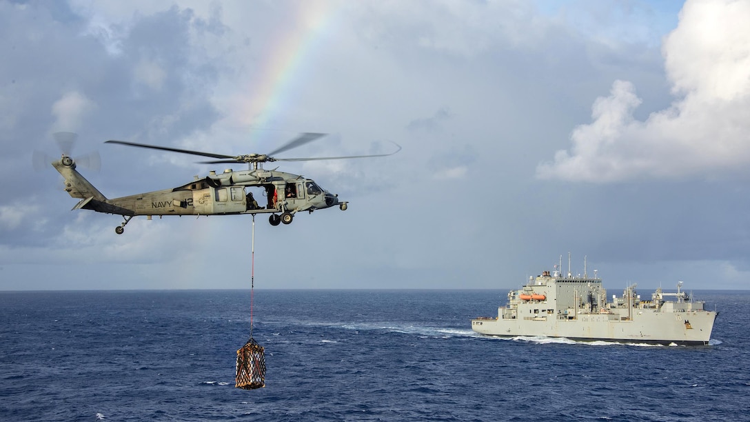 A Navy MH-60S Seahawk helicopter transfers cargo from the dry cargo and ammunition ship USNS Charles Drew to the aircraft carrier USS Carl Vinson during a vertical replenishment, Feb. 3, 2017. The helicopter crew is assigned to Helicopter Sea Combat Squadron 4. Navy photo by Petty Officer 2nd Class Sean M. Castellano