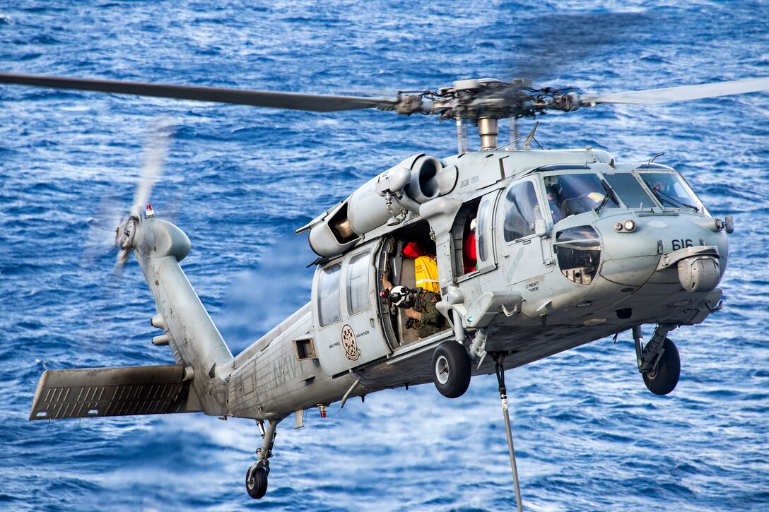 A Navy MH-60S Seahawk helicopter transfers cargo from the dry cargo and ammunition ship USNS Charles Drew to the aircraft carrier USS Carl Vinson during a vertical replenishment, Feb. 3, 2017. Navy photo by Petty Officer 2nd Class Sean M. Castellano