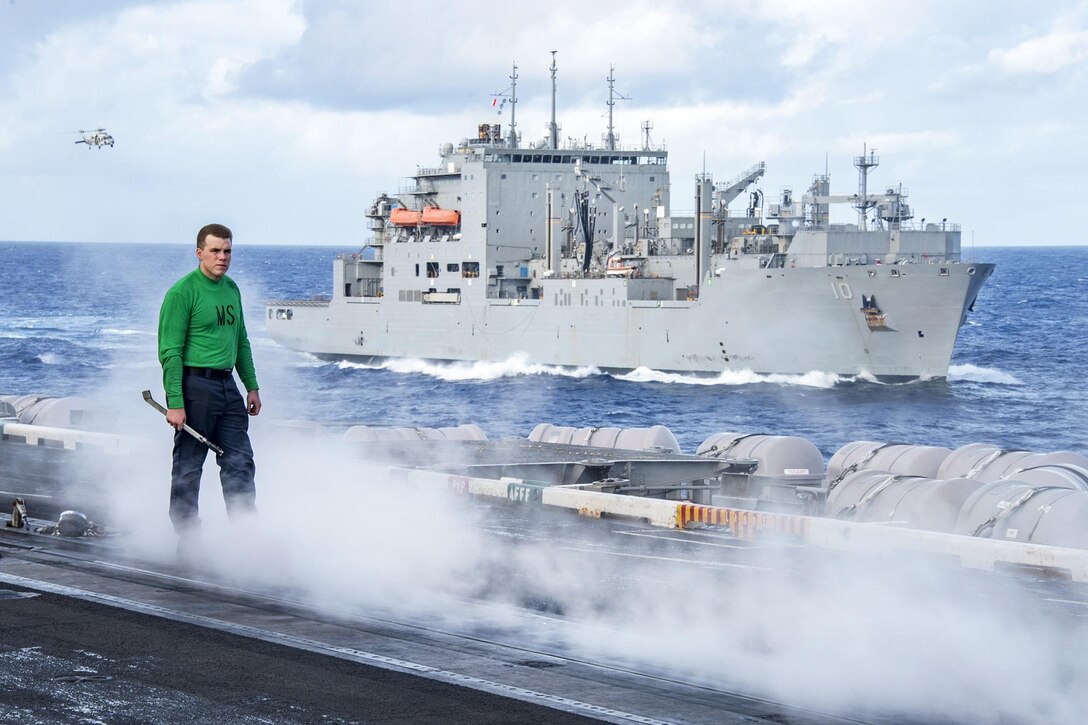 Navy Petty Officer 3rd Class Dan Triplett monitors no-load-runs of a catapult on the flight deck aboard the aircraft carrier USS Carl Vinson as the dry cargo and ammunition ship USNS Charles Drew sails in the background in the Pacific Ocean, Feb. 3, 2017. Triplett is an aviation boatswain’s mate, equipment. Navy photo by Petty Officer 2nd Class Sean M. Castellano 