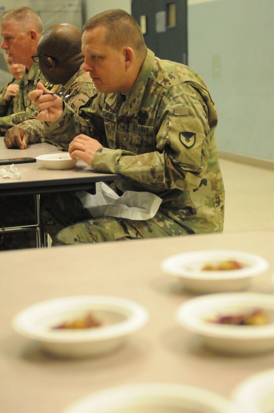 Army Reserve CW5 Bryan Campbell tries the meal the Army Reserve Culinary Arts Team out of a mobile kitchen trailer at the Orlando Armed Forces Reserve Center. The Army Reserve Culinary Arts Team was rehearsing for the upcoming 42nd Annual Military Culinary Arts Competition.