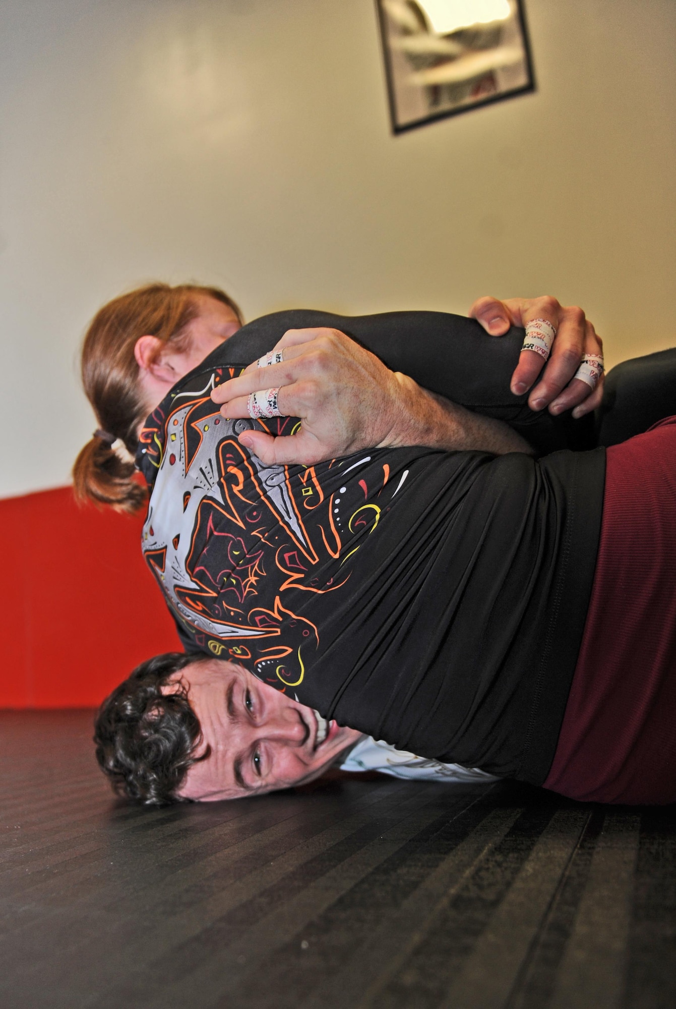 Brazilian Jiu Jitsu instructor Scott Fremming, bottom, and Melia Baxter, student, spar during a class at the fitness center on Whiteman Air Force Base, Mo., Feb. 3, 2017. The class is offered to adults and youth weekly and teaches the martial art technique of ground fighting. (U.S. Air Force photo by Tech. Sgt. Miguel Lara)