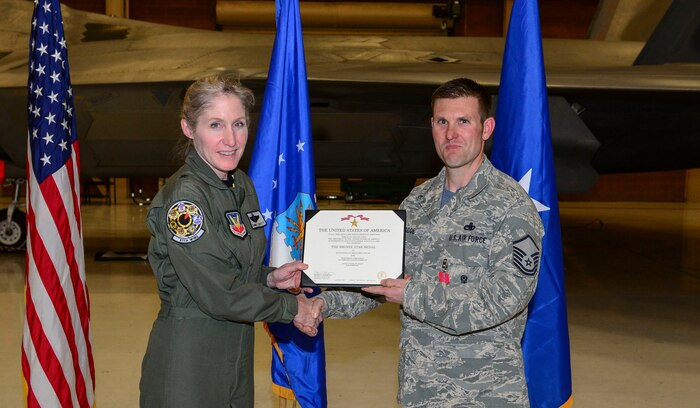 Brig. Gen. Jeannie Leavitt, 57th Wing commander, presents Master Sgt. Christopher Boscoe, 57th Aircraft Maintenance Squadron F-22 weapons section chief, with the Bronze Star Medal at Nellis Air Force Base, Nevada, Feb. 3, 2017. The Bronze Star Medal is a United States decoration awarded to members of the United States Armed Forces for either heroic achievement, heroic service, meritorious achievement or meritorious service in a combat zone. (U.S. Air Force photo by Airman 1st Class Nathan Byrnes)