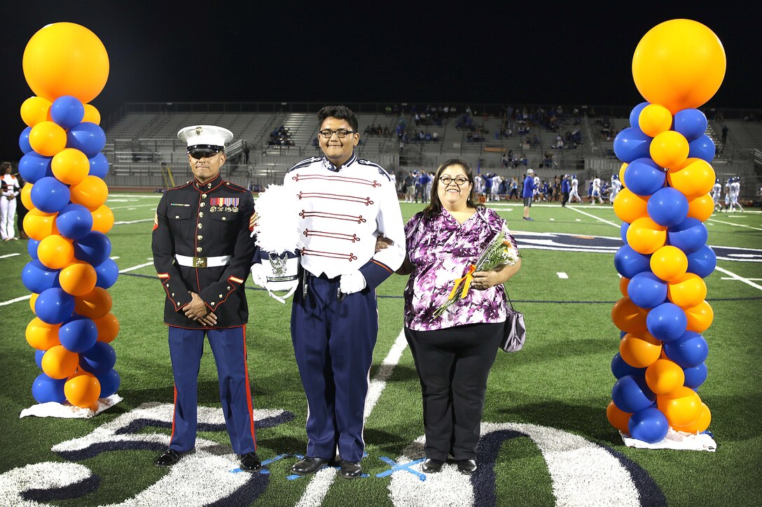 Sgt Frank Duran escorts Future Marine David Carter during senior night at Roosevelt High School Nov. 4. Carter was asked to bring someone that has influenced him in his life. Most students chose a teacher or a coach, he chose his recruiter. 