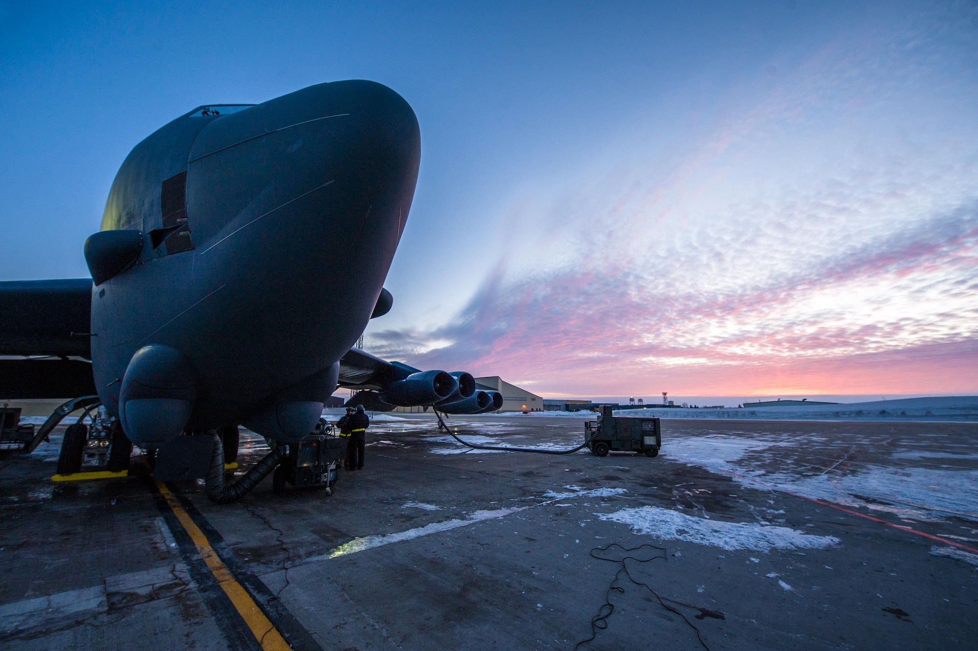 The sun rises behind a B-52H Stratofortress at Minot Air Force Base, N.D., Jan. 26, 2017. Airmen from the 5th Aircraft Maintenance Squadron work around the clock in all weather conditions to provide B-52 firepower on demand. (U.S. Air Force photo/Senior Airman J.T. Armstrong)