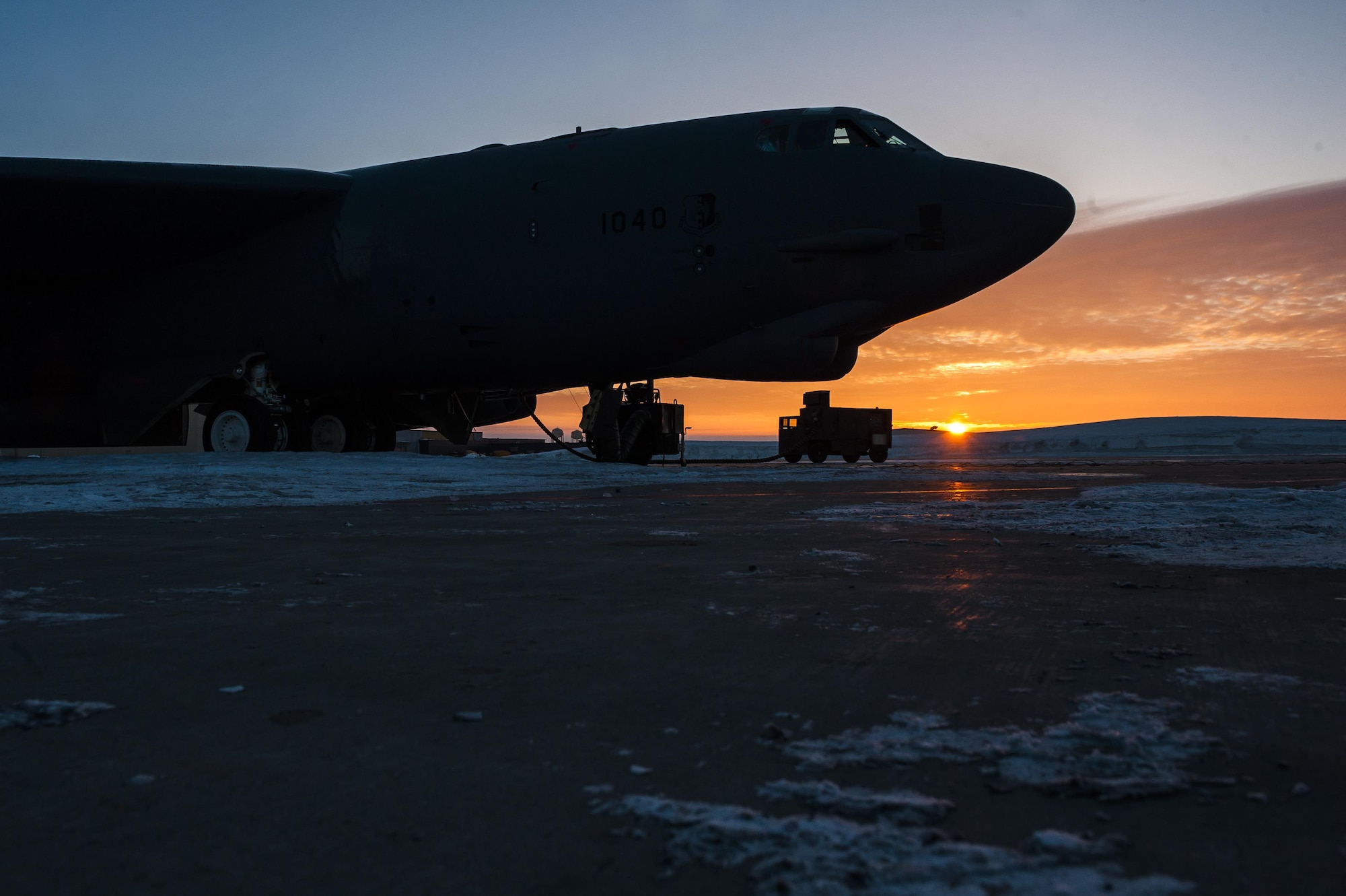 The sun rises behind a B-52H Stratofortress at Minot Air Force Base, N.D., Jan. 26, 2017. Airmen from the 5th Aircraft Maintenance Squadron work around the clock in all weather conditions to provide B-52 firepower on demand. (U.S. Air Force photo/Senior Airman J.T. Armstrong)