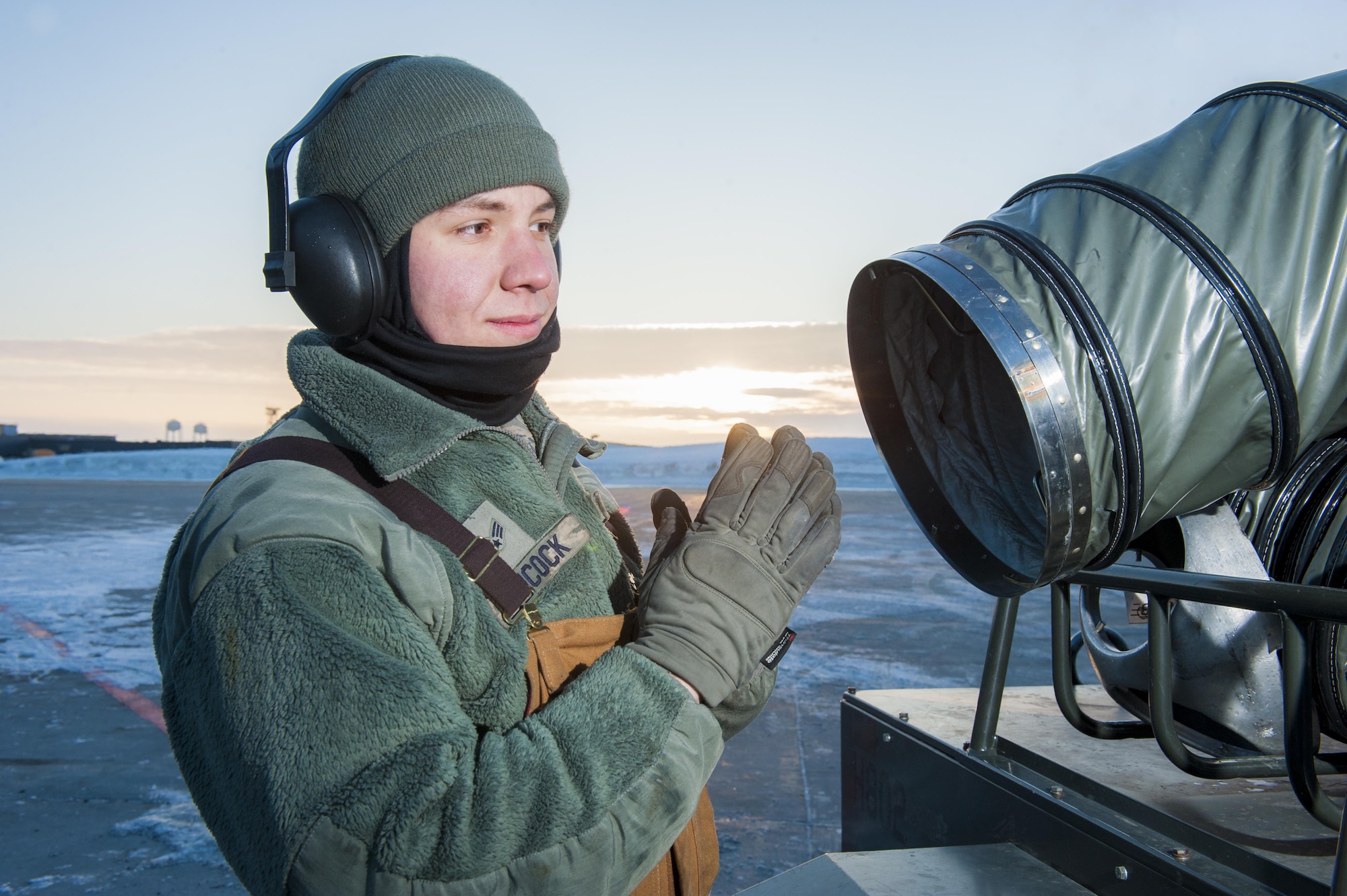 Senior Airman Daniel Hancock, 5th Aircraft Maintenance Squadron crew chief, warms his hands on the flightline at Minot Air Force Base, N.D., Jan. 26, 2017. Hancock, along with other 5th AMXS Airmen, work in harsh weather conditions to provide B-52 firepower on demand. (U.S. Air Force photo/Senior Airman J.T. Armstrong)
