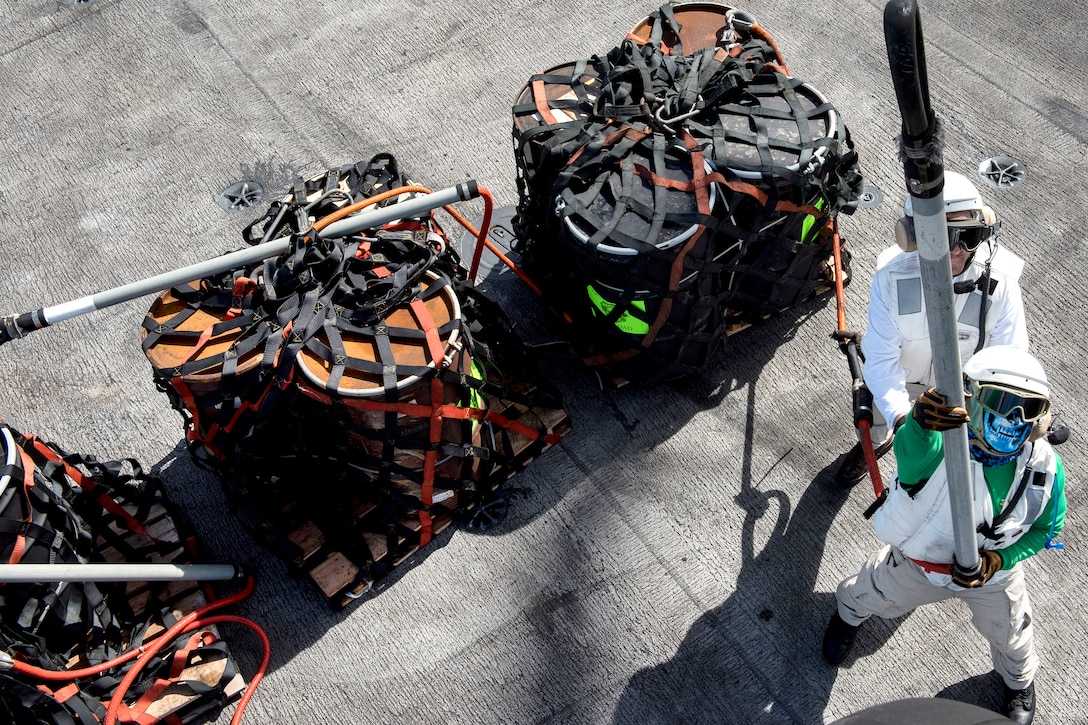 Navy Chief Petty Officer Michael Strawn, left, and Lt. Cmdr. Matthew Miller hook pallets to a Navy MH-60S Seahawk helicopter on the flight deck aboard the aircraft carrier USS Carl Vinson during a vertical replenishment with the dry cargo and ammunition ship USNS Charles Drew in the Pacific Ocean, Feb. 3, 2017. Navy photo by Petty Officer 3rd Class Matt Brown