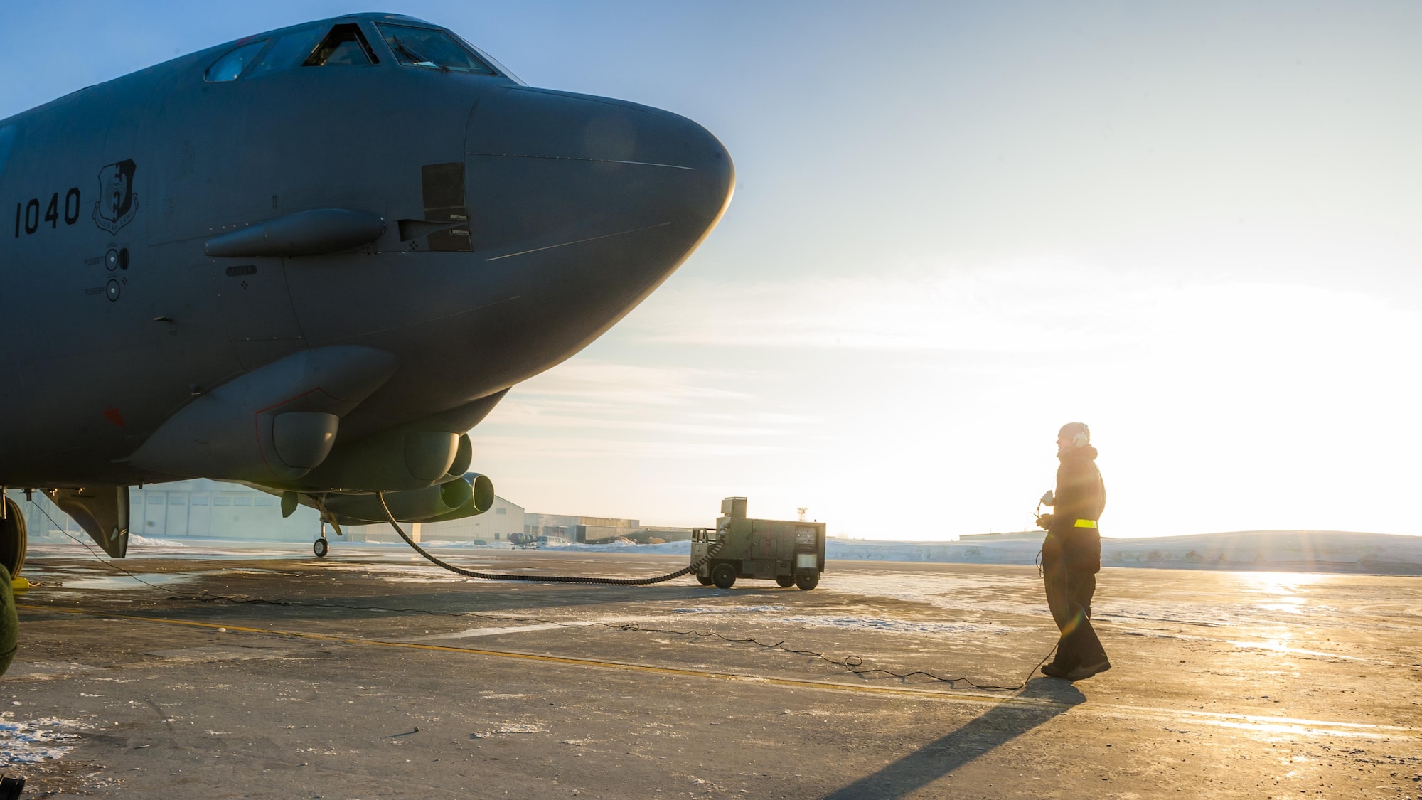 Senior Airman Josh Serafin, 5th Aircraft Maintenance Squadron crew chief, collects his headset cord prior to engines of a B-52H Stratofortress starting at Minot Air Force Base, N.D., Jan. 26, 2017. Foreign objects and debris on the flighline, aka FOD, can be pulled into the intake causing damage to the aircraft as well as a safety hazard for the aircrew. (U.S. Air Force photo/Senior Airman J.T. Armstrong)