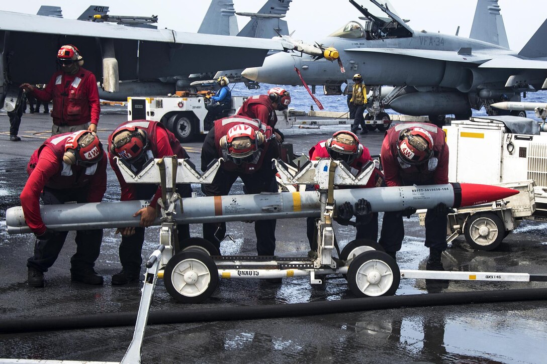 Ordnance sailors lift a missile on the flight deck of the aircraft carrier USS Carl Vinson in the Pacific Ocean, Feb. 4, 2017. Navy photo by Seaman Jake Cannady