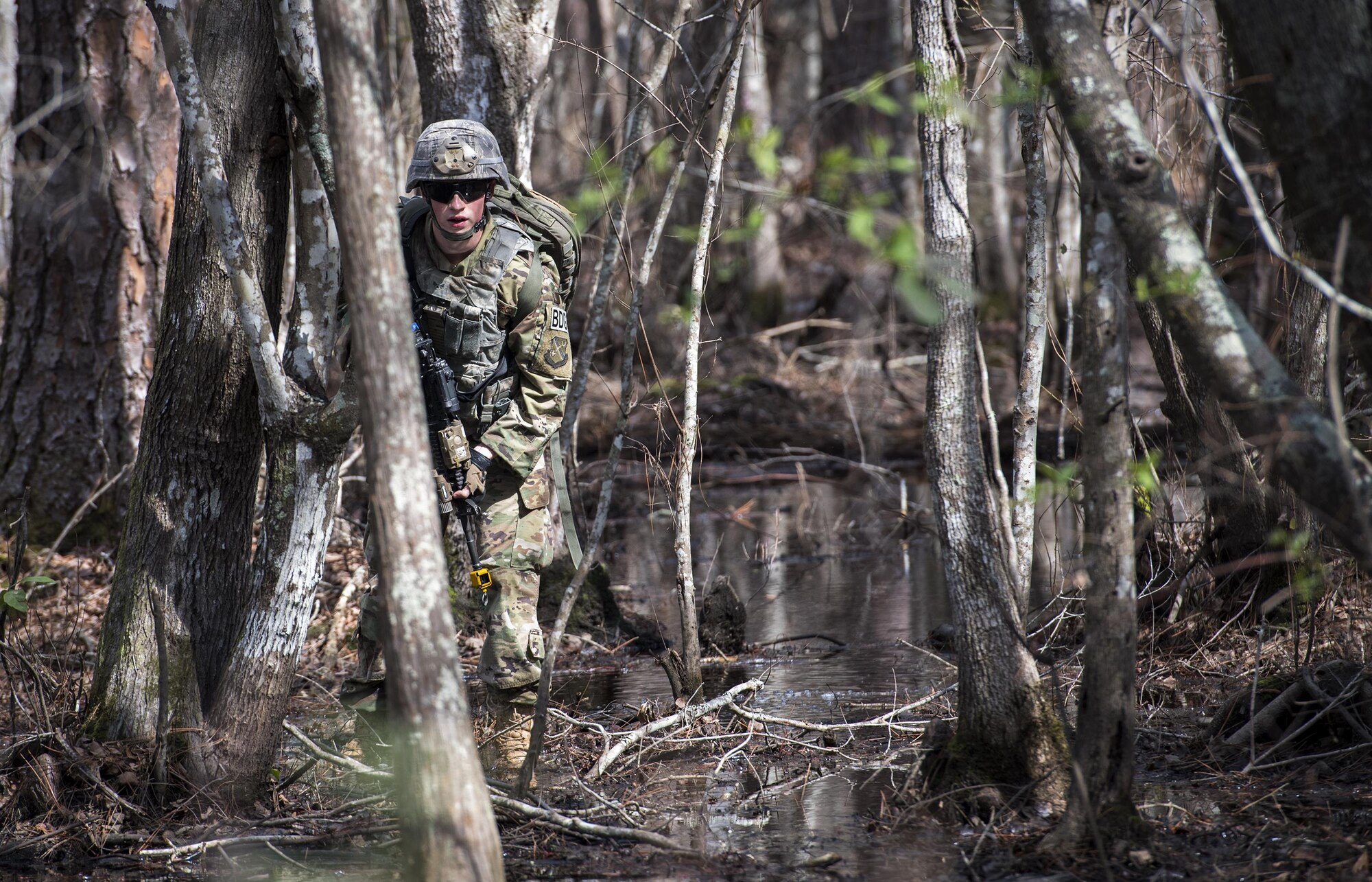 Airman 1st Class Daniel Ross, 822d Base Defense Squadron fireteam member, looks for signs of improvised explosive devices, while simulating patrolling an area outside the wire Feb. 7, 2017, at Moody Air Force Base, Ga. Airmen simulated various missions they would be tasked to complete during a deployment, including being ambushed while out on patrol, gathering intelligence from residents in the local village and raiding buildings. (U.S. Air Force photo by Airman 1st Class Janiqua P. Robinson)