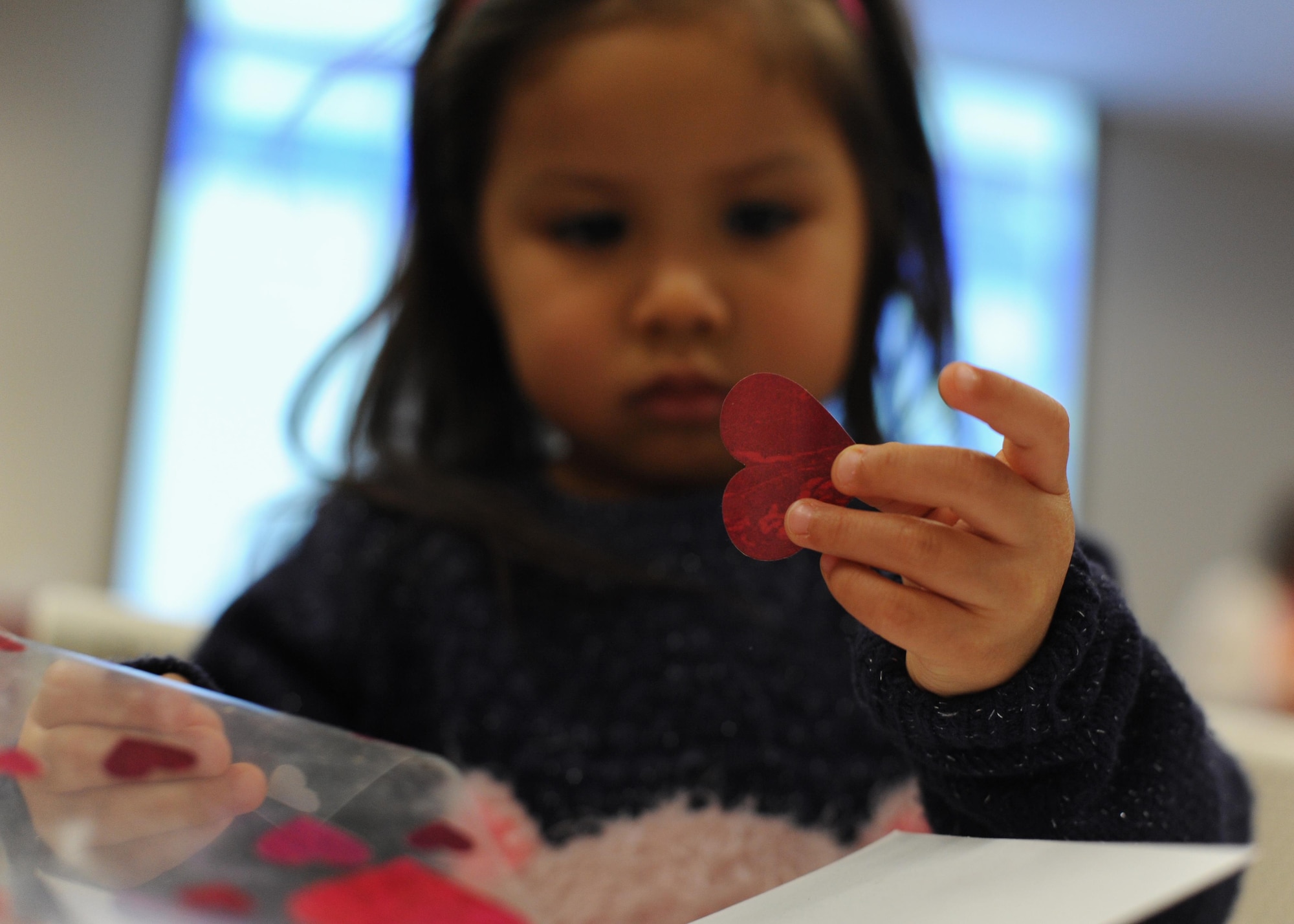 Lilyana Rodriguez, a 5-year-old, decides how to decorate a card for her family Feb. 4, 2017, during the Exceptional Family Member Program’s Valentine’s Day event, at the Airman & Family Readiness Center on Little Rock Air Force Base, Ark. The event was open to children and families enrolled in the EFMP for an afternoon of dancing and crafting. (U.S. Air Force photo by Airman 1st Class Grace Nichols)