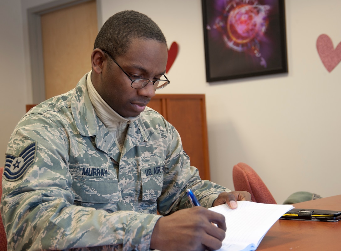 Tech. Sgt. Joseph Murray, 11th Force Support Squadron manpower analyst, writes in his notebook at the library on Joint Base Andrews, Md., Feb. 10, 2017. In October 2016, he began hosting creative writing club meetings at the library for others, like him, who want to develop expressing their thoughts and imaginations in writing. (U.S. Air Force photo by Staff Sgt. Joe Yanik)
