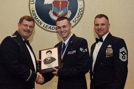 U.S Air Force Col. Gregory Gilmour, left, 315th Airlift Wing (AW) commander, and Chief Master Sgt. Mark Barber, 315th AW command chief, congratulate Senior Airman Peter Boyd, center, 628th Medical Group biomedical maintenance technician, for receiving the John L. Levitow Award during an Airman Leadership School Graduation ceremony Feb. 9, 2017, at Joint Base Charleston, South Carolina. The Levitow Award is the highest honor bestowed during ALS and is awarded to the Airman who displays the highest level of leadership qualities.