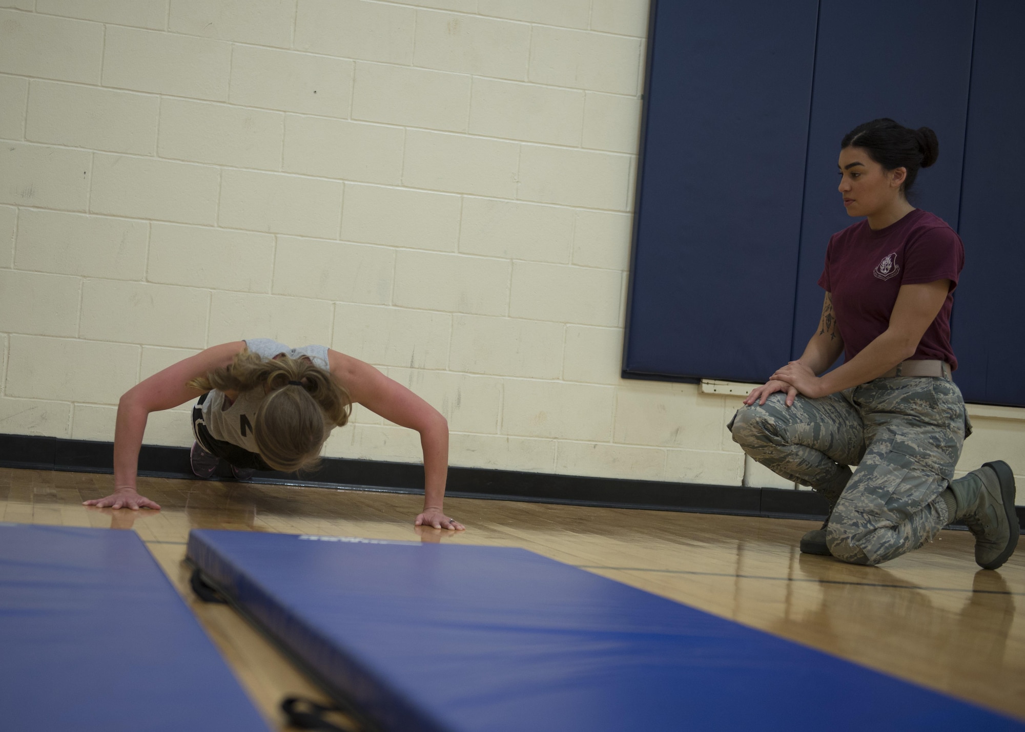 U.S. Air Force Airman First Class Alondra Santos; 97th Medical Operations Squadron commanders support staff; watches Stacey Staunton; 97th MDOS secretary of office automation; do pushups for the Black History Month Fitness Challenge; Feb. 3; 2017; at Altus Air Force Base; Oklahoma. The fitness challenge kicks off Black History Month celebrations and will be followed; the Open Mic Night; Feb. 25. (U.S. Air Force photo by Airman Jackson N. Haddon/ Released)