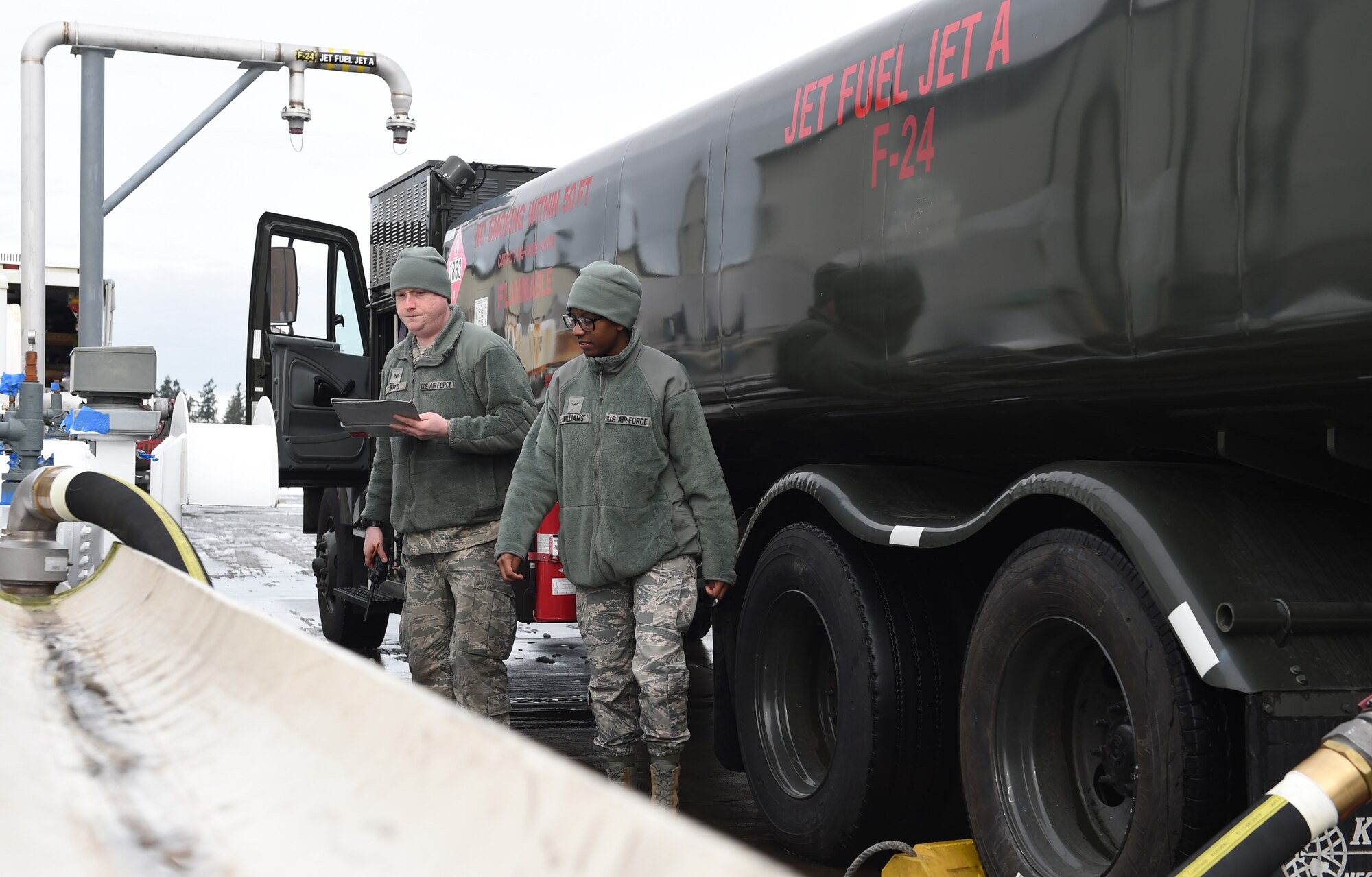 Senior Airman Mason Boyd (Left) and Airman Katara Williams, 627th Logistics Readiness Squadron fuels apprentices, add fuel to a fuel truck on Joint Base Lewis-McChord, Wash., Feb. 7, 2017. The 627th LRS has 11 fuel trucks, which have 6,000 gallon tanks that can issue up to 600 gallons per minute each. (Air Force Photo/ Staff Sgt. Naomi Shipley)