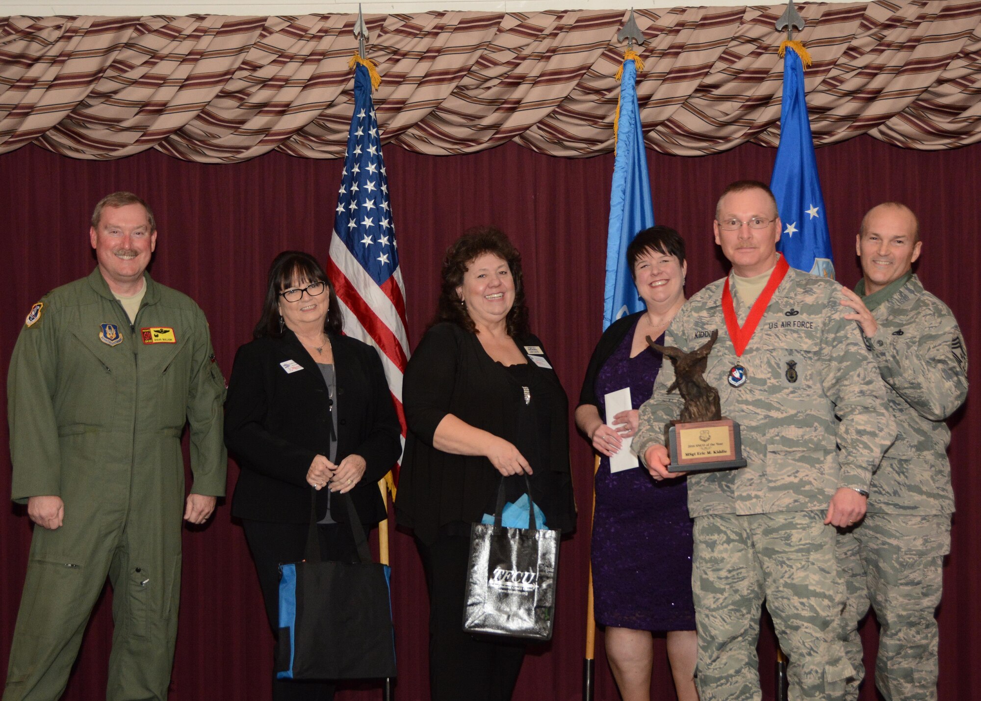 Master Sgt. Eric Kiddie of the 507th Security Forces Squadron accepts his award for Senior NCO of the Year Feb. 4, 2017, in the Tinker Club Ballroom at Tinker Air Force Base, Okla. Col. Doug Gullion, 507th Air Refueling Wing commander, Jan Davis, assistant vice president and branch manager of Tinker Federal Credit Union, Kathy Gillette, president and CEO of the Moore Chamber of Commerce, Tanya Windisch, assistant branch manager of Tinker Federal Credit Union and Chief Master Sgt. Stephen Brown, 507th ARW command chief, were on hand to present the award. (U.S. Air Force photo/Tech. Sgt. Lauren Gleason)