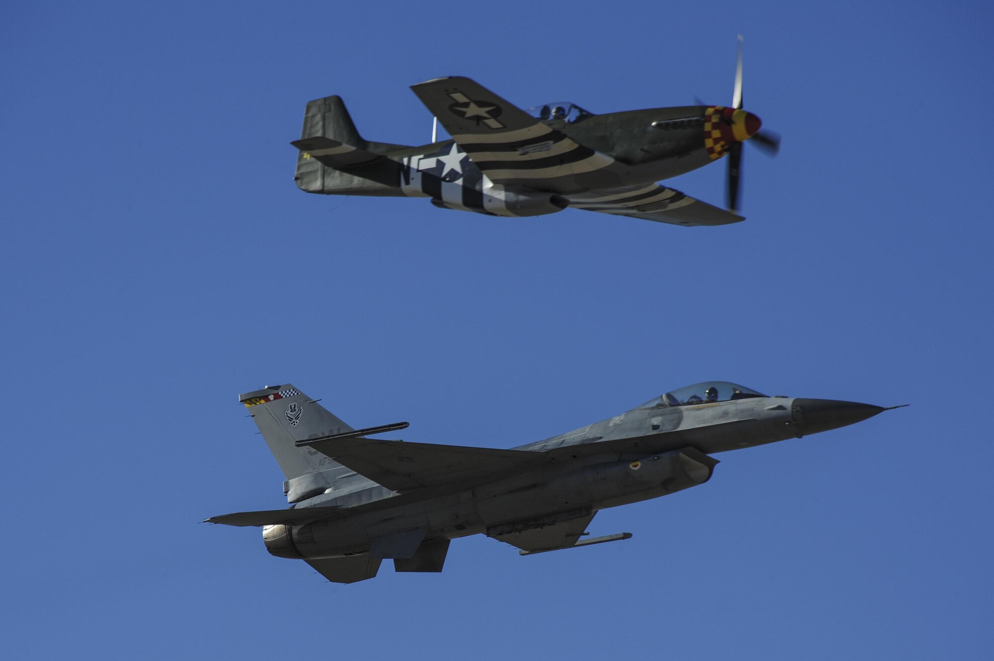 A U.S. Air Force F-16C Fighting Falcon and a P-51 Mustang fly in formation during the 2017 Heritage Flight Training and Certification Course at Davis-Monthan Air Force Base, Ariz., Feb. 10, 2017. The course provides civilian and military pilots the opportunity to practice flying in formation together in preparation for future air shows. (U.S. Air Force photo by Airman 1st Class Mya M. Crosby)