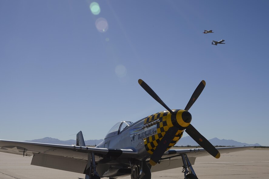 A P-47 Thunderbolt and a U.S. Air Force A-10C Thunderbolt II fly above a P-51 Mustang during the 2017 Heritage Flight Training and Certification Course at Davis-Monthan Air Force Base, Ariz., Feb. 10, 2017. The HFTCC provides civilian and military pilots the opportunity to practice flying in formation together in preparation for future air shows. (U.S. Air Force photo by Senior Airman Ashley N. Steffen)