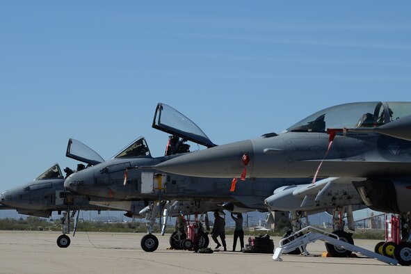 Two U.S. Air Force A-10C Thunderbolt IIs and an F-16 Fighting Falcon rest on the flightline during the 2017 Heritage Flight Training and Certification Course at Davis-Monthan Air Force Base, Ariz., Feb. 10, 2017. The modern aircraft that participated in this year's HFTCC were the F-35 Lightning II, the F-22 Raptor, F-16 Fighting Falcon and the A-10C Thunderbolt II. The historic aircraft included the P-51 and T-51 Mustangs, the P-40 Warhawk, the P-38 Lightning, the P-47 Thunderbolt, the T-33 Shooting Star and the F-86 Sabre. (U.S. Air Force photo by Senior Airman Ashley N. Steffen)