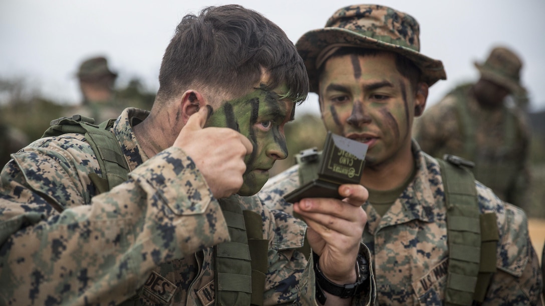 Marine Corps Lance Cpl. Lane Fernandes, left, and Cpl. Fransico Hernandez apply camouflage face paint to prepare for a patrol exercise at the Jungle Warfare Training Center at Camp Gonsalves, Okinawa, Japan, Jan. 25, 2017. Fernandes and Hernandez are infantrymen assigned to Fox Company, Battalion Landing Team, 2nd Battalion, 5th Marine Regiment, 31st Marine Expeditionary Unit. Marine Corps photo by Lance Cpl. Breanna Weisenberger