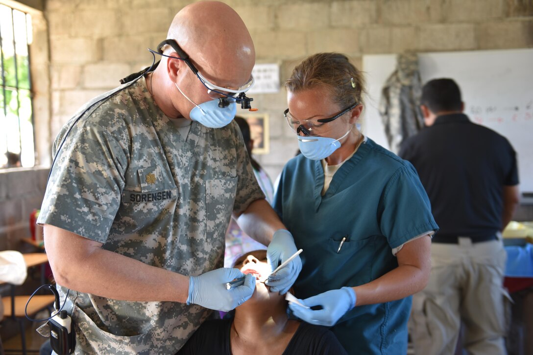 U.S. Army Maj. Eric Sorensen and Sgt. Charissa Youngs, Joint Task Force-Bravo Medical Element, perform an extraction on a patient during a Medical Readiness Training Exercise in Estancia, La Paz, Jan. 31. Personnel from JTF-Bravo worked side by side with local nurses and physicians, as well as Honduran soldiers to provide the population with immunizations, preventive medicine, dental services, basic medical care and pharmacy services during the two-day mission. (U.S. Army photo by Maria Pinel)