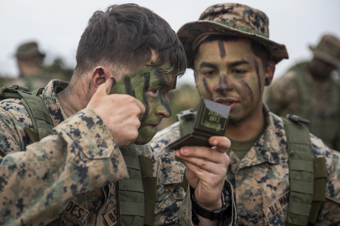 Marine Corps Lance Cpl. Lane Fernandes, left, and Cpl. Fransico Hernandez apply camouflage face paint to prepare for a patrol exercise at the Jungle Warfare Training Center at Camp Gonsalves, Okinawa, Japan, Jan. 25, 2017. Fernandes and Hernandez are infantrymen assigned to Fox Company, Battalion Landing Team, 2nd Battalion, 5th Marine Regiment, 31st Marine Expeditionary Unit. Marine Corps photo by Lance Cpl. Breanna Weisenberger