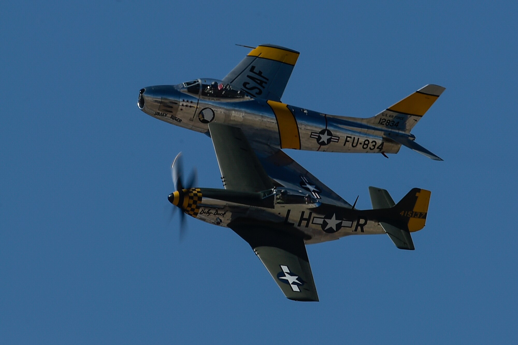 A P-51 Mustang and an F-86 Sabre fly together during the 2017 Heritage Flight Training and Certification Course at Davis-Monthan Air Force Base, Ariz., Feb. 10, 2017. During the course, aircrews practice ground and flight training to enable civilian pilots of historic military aircraft and U.S. Air Force pilots of current fighter aircraft to fly safely in formations together. (U.S. Air Force photo by Senior Airman Chris Drzazgowski)