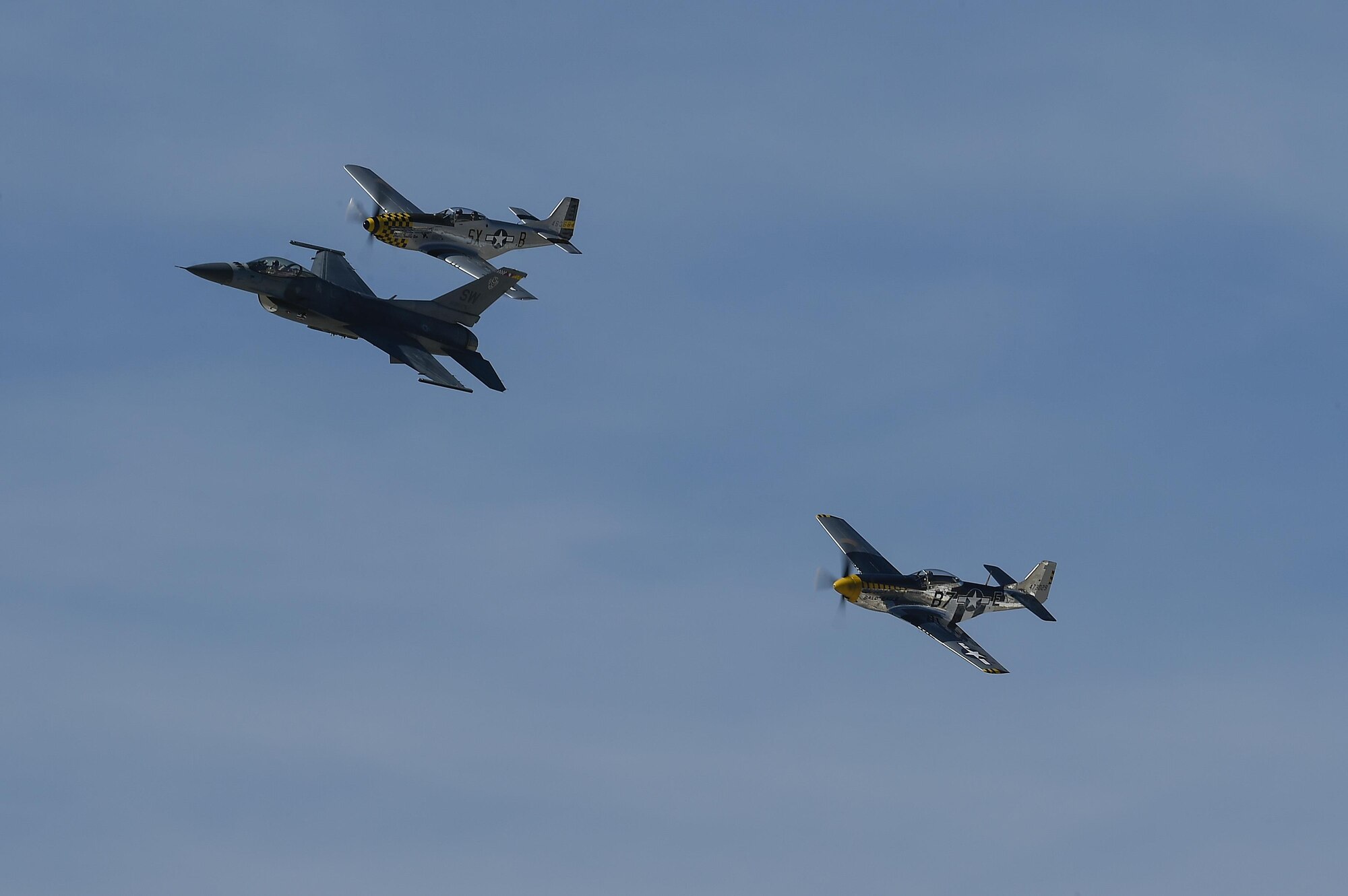 A U.S. Air Force F-16 Fighting Falcon and two P-51 Mustangs fly together during the 2017 Heritage Flight Training and Certification Course at Davis-Monthan Air Force Base, Ariz., Feb. 10, 2017. During the course, aircrews practice ground and flight training to enable civilian pilots of historic military aircraft and U.S. Air Force pilots of current fighter aircraft to fly safely in formations together. (U.S. Air Force photo by Senior Airman Chris Drzazgowski)