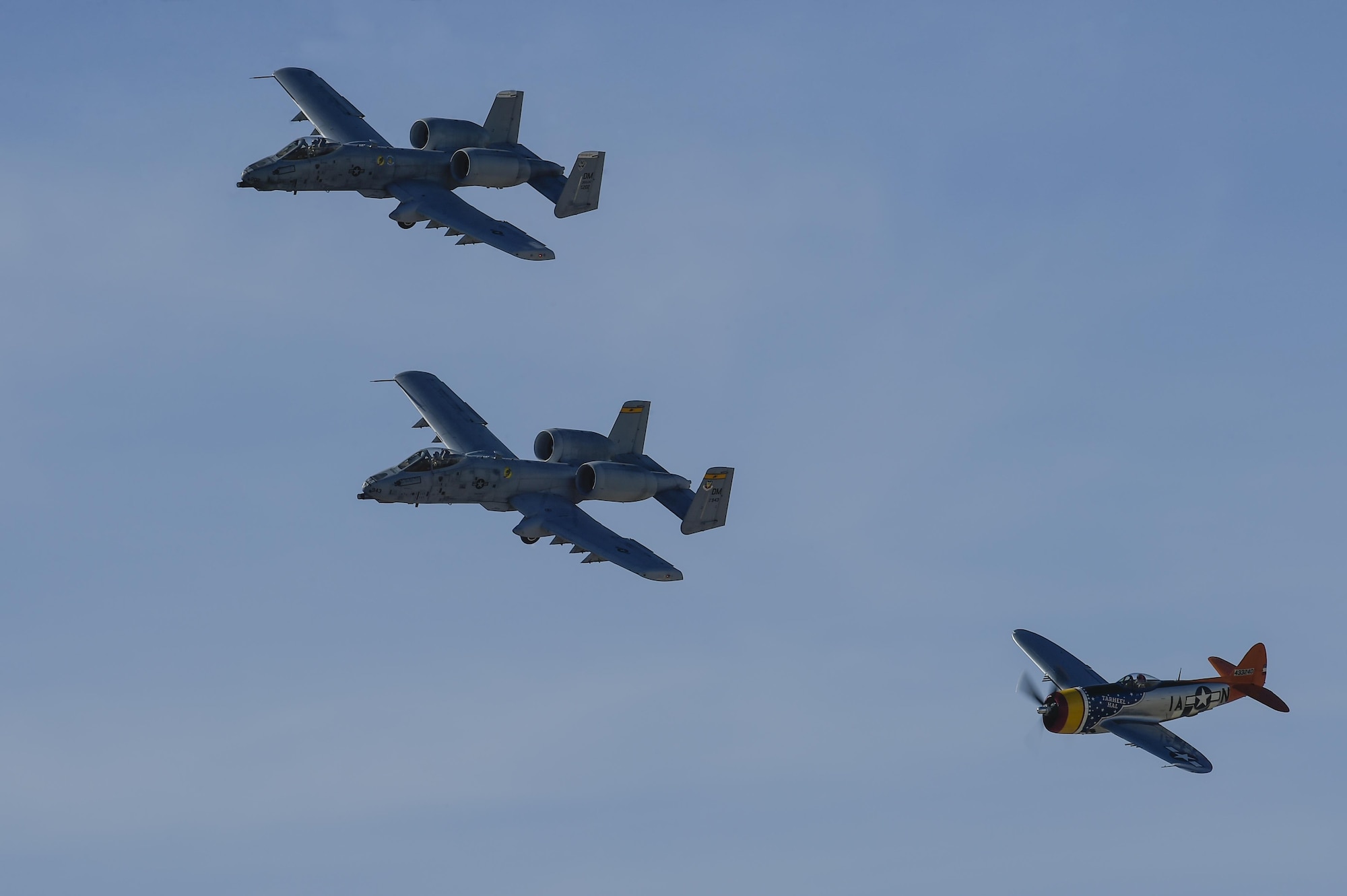 Two U.S. Air Force A-10C Thunderbolt IIs and a P-47 Thunderbolt fly together during the 2017 Heritage Flight Training and Certification Course at Davis-Monthan Air Force Base, Ariz., Feb. 10, 2017. The 20th annual training event has been held at D-M since 2001 and features aerial demonstrations from historical and modern fighter aircraft. (U.S. Air Force photo by Senior Airman Chris Drzazgowski)