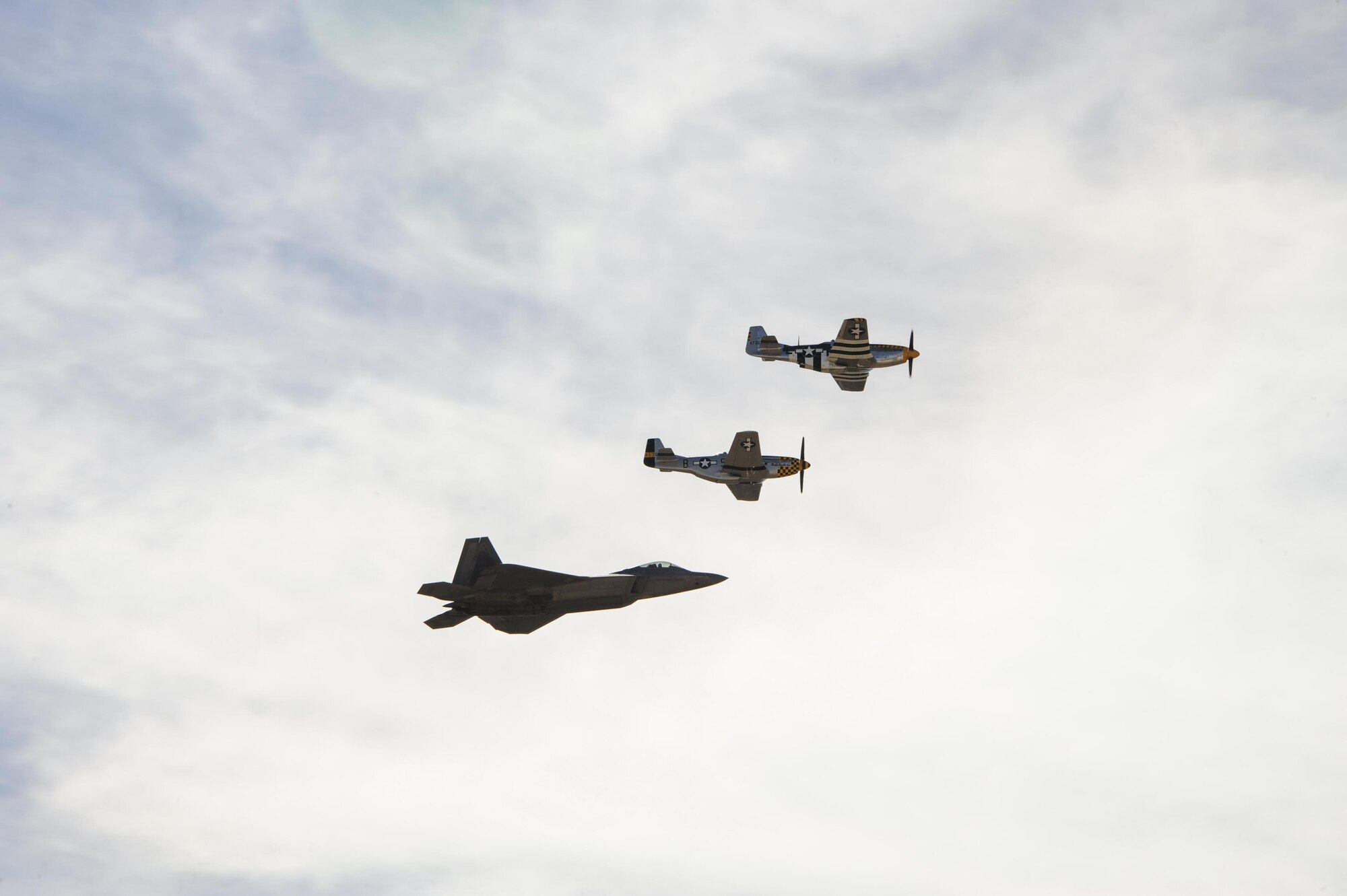 A U.S. Air Force F-22 Raptor and two P-51 Mustangs fly in formation during the 2017 Heritage Flight Training and Certification Course at Davis-Monthan Air Force Base, Ariz., Feb. 9, 2017. The HFTCC provides civilian and military pilots the opportunity to practice flying in formation together in preparation for future air shows. (U.S. Air Force Photo by Airman 1st Class Nathan H. Barbour)