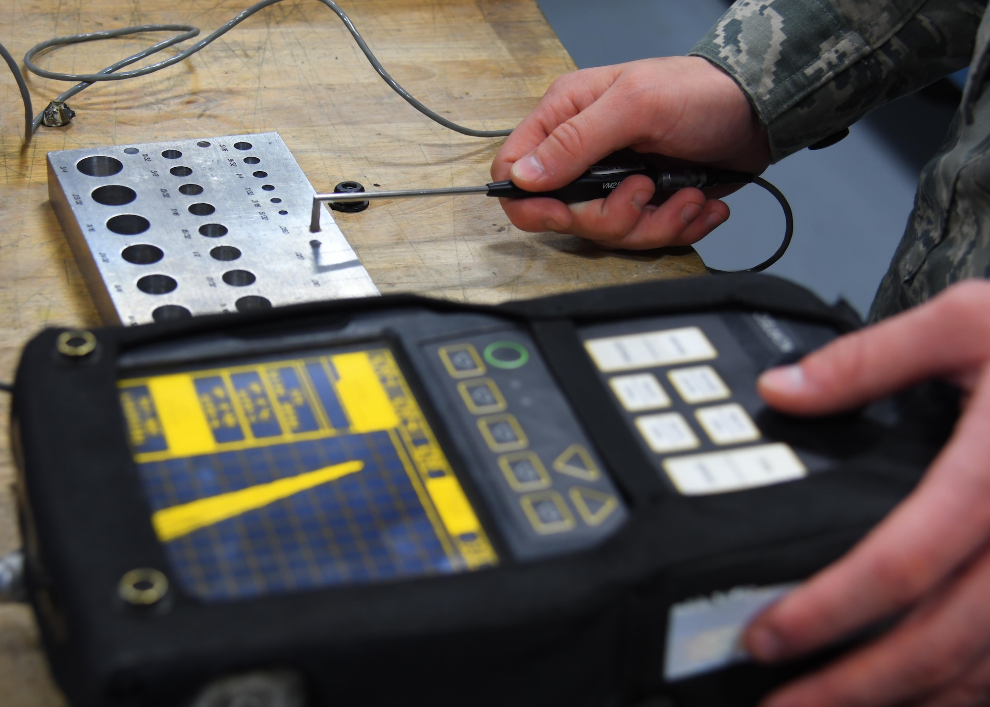 U.S. Air Force Senior Airman Devin Jordan, a non-destructive inspection journeyman with the 379th Expeditionary Maintenance Squadron Fabrication Flight, calibrates an eddy current unit at Al Udeid Air Base, Qatar, Feb. 9, 2017. This unit uses electric current to detect surface-level defects in metal on aircraft. (U.S. Air Force photo by Senior Airman Miles Wilson)