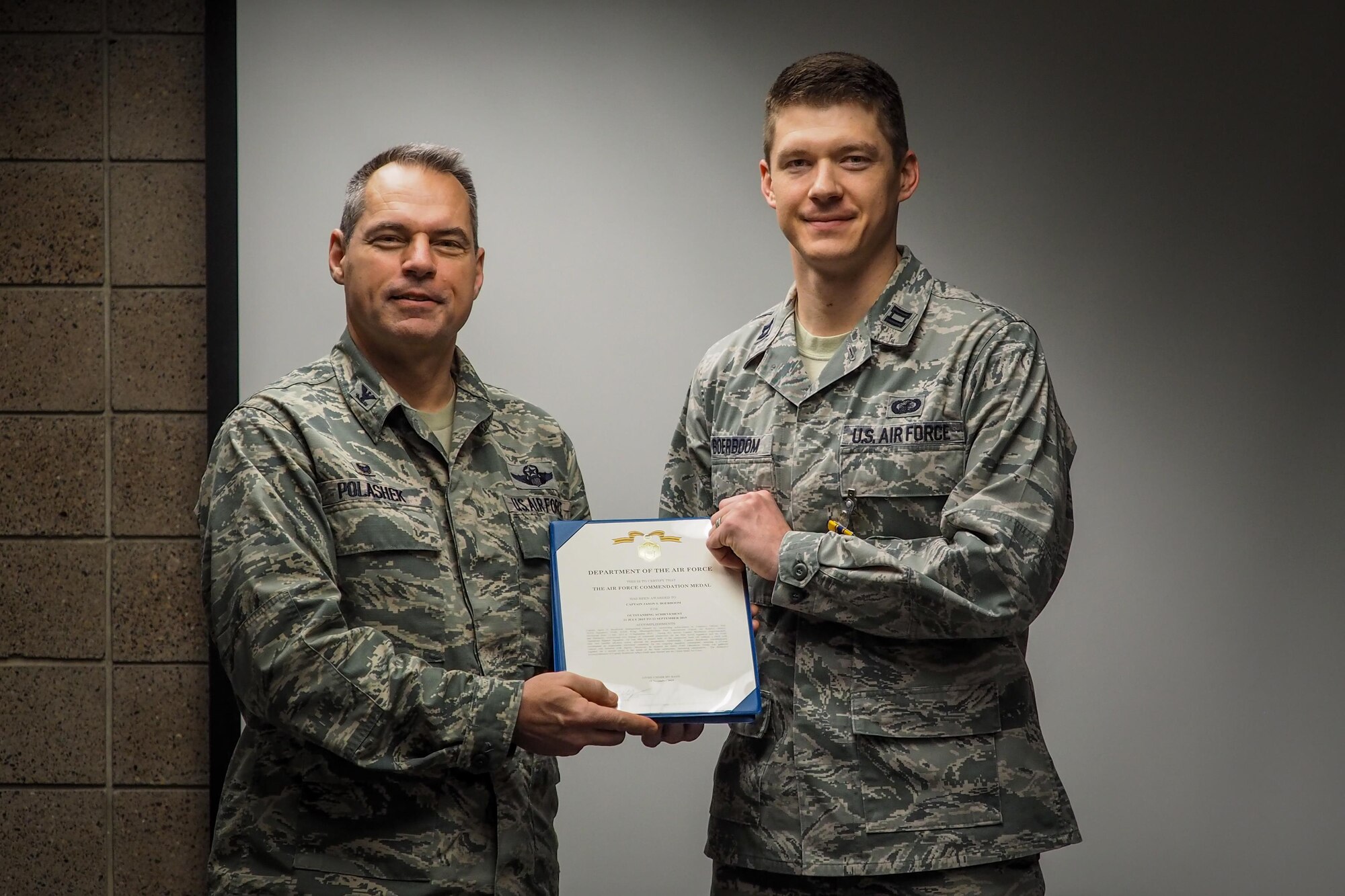 Col. Anthony Polashek, 934th Airlift Wing commander, presents Capt. Jason Boerboom with the Air Force Commendation Medal for outstanding achievement Feb. 11 during the wing staff commander's call of the February UTA.