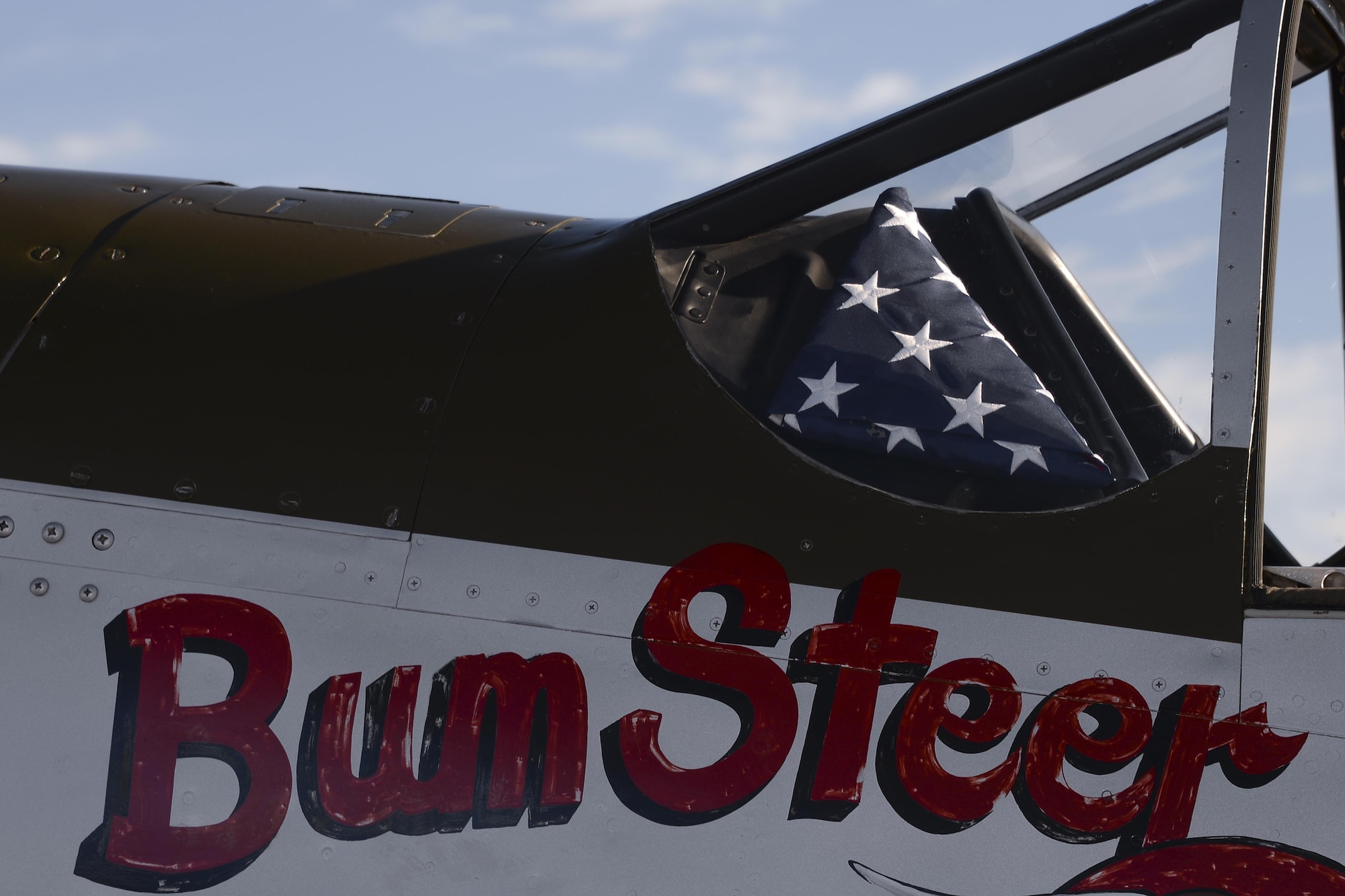 An American flag rests in a P-51 Mustang as it taxis down the flightline during the 2017 Heritage Flight Training and Certification Course at Davis-Monthan Air Force Base, Ariz., Feb. 11, 2017. The annual aerial demonstration training event has been held at D-M since 2001. (U.S. Air Force photo by Senior Airman Ashley N. Steffen)