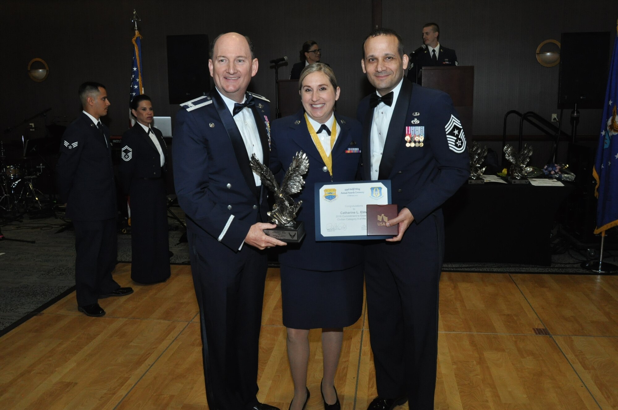 (Left) Col. Thomas K. Smith, Jr., 433rd Airlift Wing commander, and (Right) Chief Master Sgt. Brian Pinsky, 433rd AW command chief, present Catherine Elms, 433rd Force Support Squadron, the Civilian Category II annual award at the Alamo Wing’s Annual Award Banquet held at the Courtyard SeaWorld San Antonio Feb. 11, 2017. (U.S. Air Force photo/Senior Airman Bryan Swink)