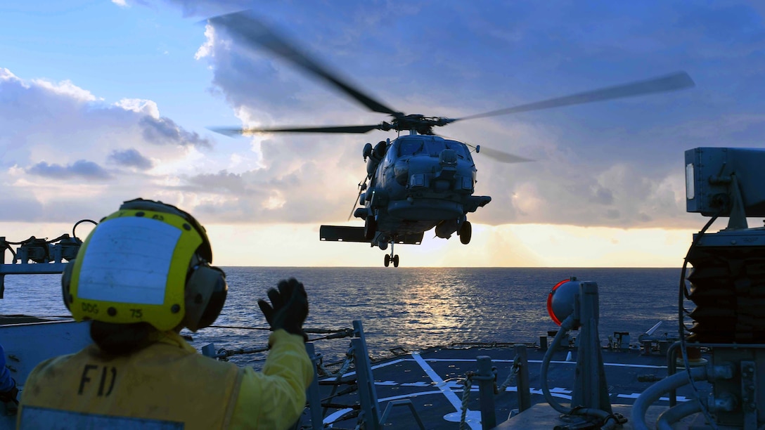 Seaman Dyamond P. Khammanivong signals to a helicopter hovering above the USS Donald Cook in the Mediterranean Sea, Feb. 8, 2017. Donald Cook, an Arleigh Burke-class guided-missile destroyer, is conducting naval operations in support of U.S. national security interests in Europe and Africa. Navy photo by Petty Officer 3rd Class Alyssa Weeks
