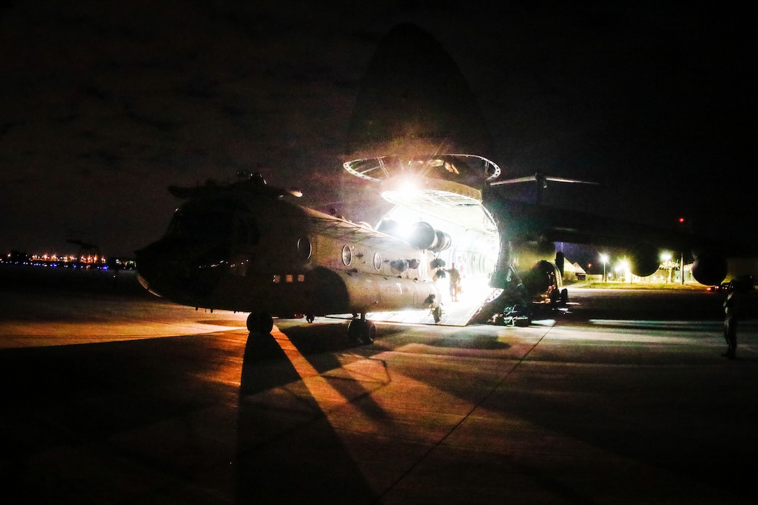 Soldiers and airmen guide a CH-47F Chinook helicopter off a C-5M Super Galaxy aircraft at Pope Army Airfield, Fort Bragg, N.C., Feb. 11, 2017. Army Photo by Sgt. Steven Galimore