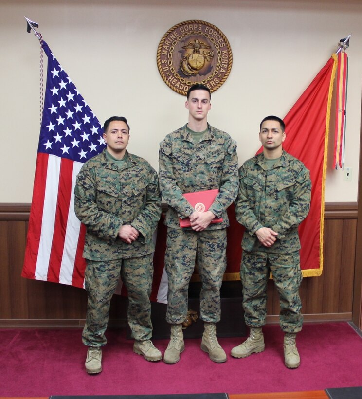 Newly pinned Sergeant Matthew DeCandio, a Cyber Network Operator, with U. S. Marine Corps Forces Korea stands with MSgt Navarro and GySgt Gussman following his promotion ceremony at the MARFORK Headquarters building aboard USAG Yongsan Seoul, South Korea.
