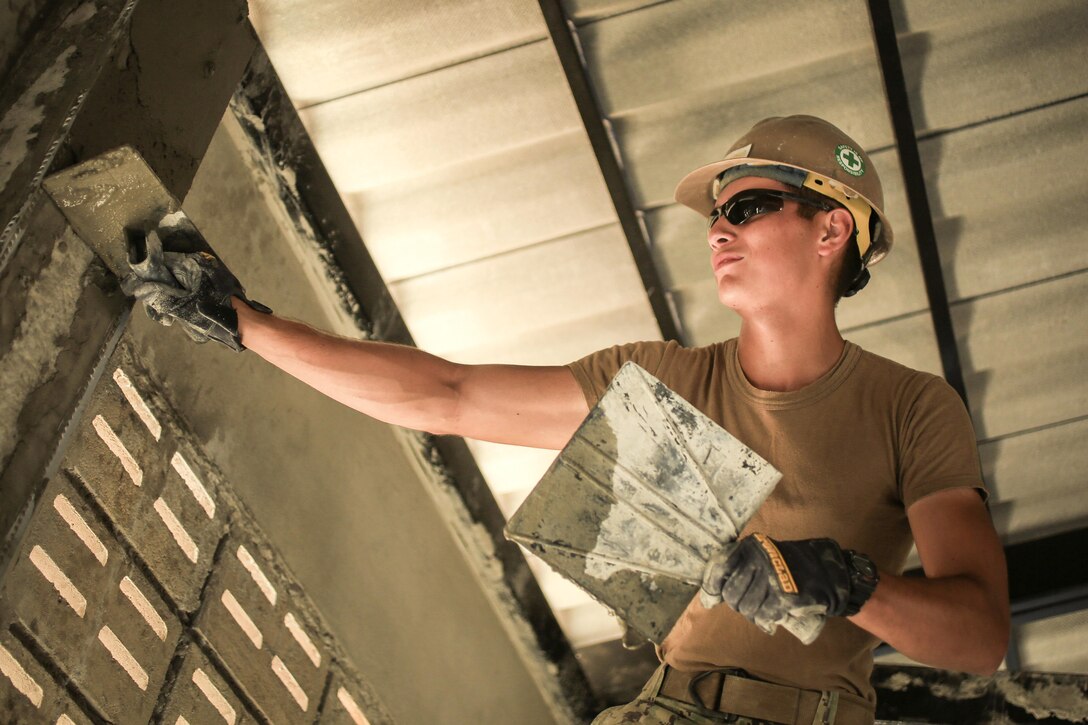 Navy Seaman Richard Robledo applies stucco to a wall during the construction of a classroom during  exercise Cobra Gold at Ban Nong Muang School, Rayong Province, Thailand, Feb. 10, 2017. Robledo is a construction equipment operator assigned to Naval Mobile Construction Battalion 5. Cobra Gold focuses on humanitarian civic action, community engagement, and medical activities to support the needs and humanitarian interest of civilian populations around the region. Marine Corps photo by Cpl. Wesley Timm