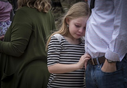 U.S. Army Reserve Capt. Mike Robertson’s niece, Ellie, leans on a family member after watching her uncle drive away with Detachment 6, 335th Signal Command (Theater) for a nine-month deployment to the Middle East, Feb. 12, 2017. 